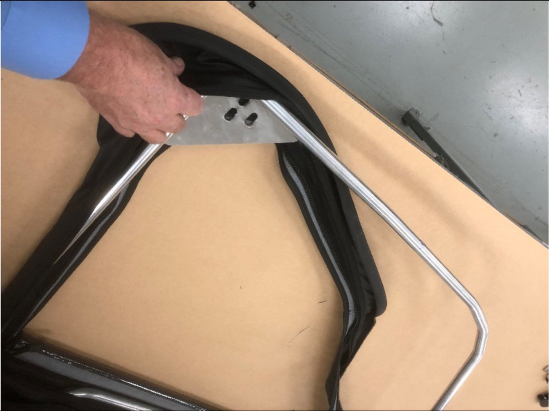 Fabric skin stretched around the upper rear corner of the door frame